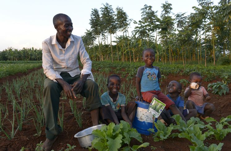 TANSANIA, Tarime Distrikt, MFEC - Mogabiri Farm Extension Centre, Dorf Kewamaba, Hof von Isaya Mwita, 34 Jahre, und seiner Frau Grace, 23 Jahre, Isaya und Kinder im Gemuesegarten am Abend