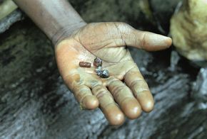Dreckige Hand mit ein paar Brökchen Coltan
