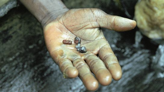 Dreckige Hand mit ein paar Brökchen Coltan