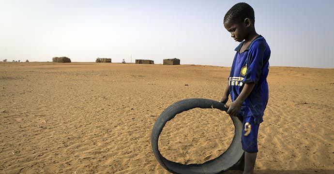 Fortschreitende Wuestenbildung und Duerre in der Sahelregion. Eine Sandduene bewegt sich immer weiter auf das Dorf Boulo Koogo zu.