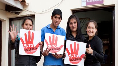 Auszubildende Jimena Arancibia, Janeth Partes Amachuy, Pablo Cruz und Lourdes "Luli" Lara halten Plakate in die Kamera