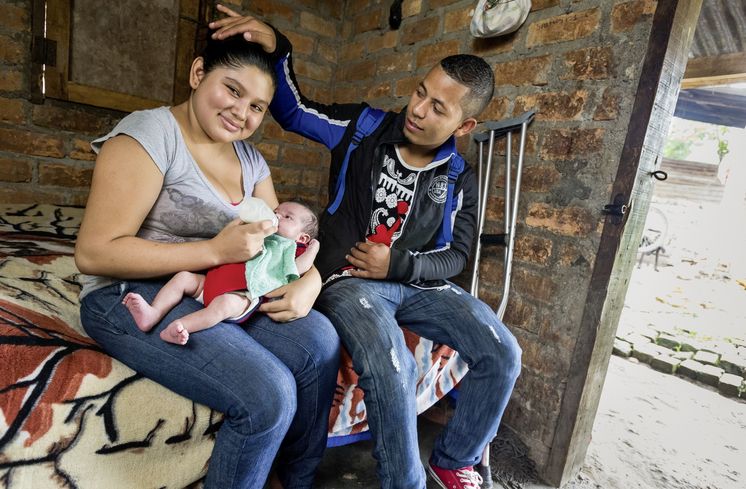 Der beidbeinig amputierte Miguel Elcides (21 Jahre) zusammen mit seiner Freundin Heidi Partricia (16 Jahre) und ihrer gemeinsamen Tochter Marcella (3 Wochen) in ihrer Behausung.