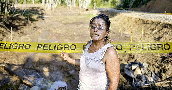 Belia am Rand der verseuchten Fläche - Regenwald, der vor über 10 Jahren nach dem Bruch einer Piepline von Öl verseucht und seither nicht nutzbar ist. Nach jahrelangem Streit ist die Erdölgesellschaft nun endlich bereit, den Schaden zu beheben und die Fläche zu reinigen, Anwesen des Ehepaares Belia Vaca (53 Jahre) und Galo Rodgrigues (63), Ort "Y del Mitad del Mundo", Provinz Sucumbíos, Ecuador; Foto: Florian Kopp / Brot für die Welt