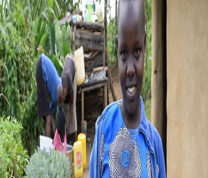 Projekt Förderung von Kleinbauern bei Diversifizierung und Verbesserung im Anbau für mehr Nahrungssicherheit, Dorf Chepsangor, Hof der Farmer Edwin und Mary Lagat, Enkelin Betty mit Bohnen.Projektpartner: ADS-NR- Anglican Devel-opment Services - North Rift