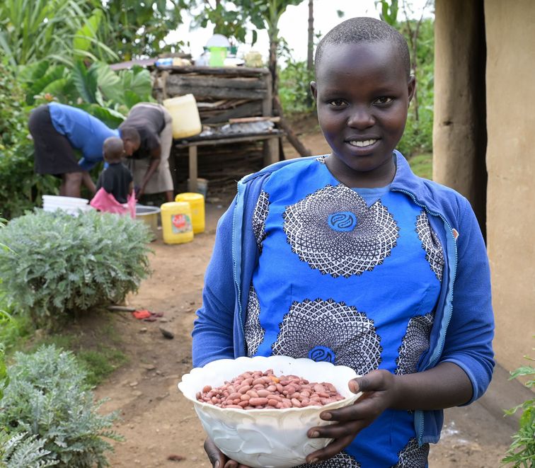 Projekt Förderung von Kleinbauern bei Diversifizierung und Verbesserung im Anbau für mehr Nahrungssicherheit, Dorf Chepsangor, Hof der Farmer Edwin und Mary Lagat, Enkelin Betty mit Bohnen.Projektpartner:  ADS-NR- Anglican Devel-opment Services - North Rift