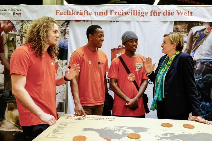 Pfarrerin Dr. Dagmar Pruin (r.), Präsidentin von Brot für die Welt und Diakonie Katastrophenhilfe im Gespräch mit Freiwilligen am Messestand von den Fachkräften und Freiwilligendienst bei Brot für die Welt auf dem Messegelände, beim Kirchentag 2023 in Nürnberg.