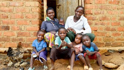 Familienfoto von Isaya Mwita, seiner Frau Grace und mit ihren fünf Kindern vor ihrem Haus