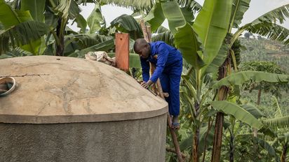 Maurer Pedson Biryomunsi zeigt, wie man einen von ACORD gebauten Wassertank auf dem Grundstück eines Hauses im Distrikt Rwampara baut und reinigt. Projektpartner: ACORD - Agency for Cooperation in Research and Development