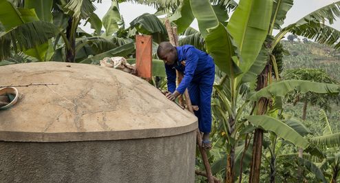 Maurer Pedson Biryomunsi zeigt, wie man einen von ACORD gebauten Wassertank auf dem Grundstück eines Hauses im Distrikt Rwampara baut und reinigt. Projektpartner: ACORD - Agency for Cooperation in Research and Development