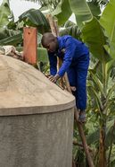 Maurer Pedson Biryomunsi zeigt, wie man einen von ACORD gebauten Wassertank auf dem Grundstück eines Hauses im Distrikt Rwampara baut und reinigt. Projektpartner: ACORD - Agency for Cooperation in Research and Development