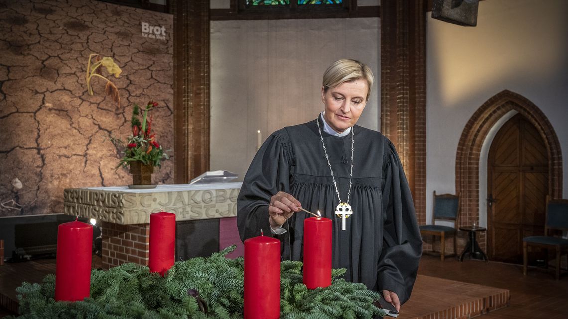 Zum 1. Advent entzündet Dagmar Pruin die erste Kerze eines großen Adventskranzes