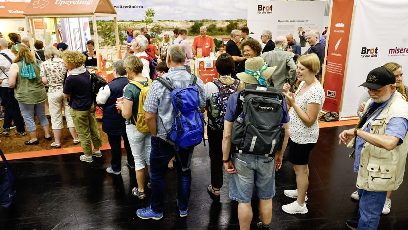 Schlange wartender Menschen vor dem Messestand von Brot für die Welt und Missio 