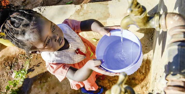 KENIA, ADS Anglican Development Services of Mount Kenya East, Stadt Embu, Dorf Gichunguri, Projekt Regenwasserauffang an einem Felsen und Speicherung in Tanks zur Nutzung in Duerreperioden, Agnes Irima, 44 Jahre, und Enkelin an Wasserstelle