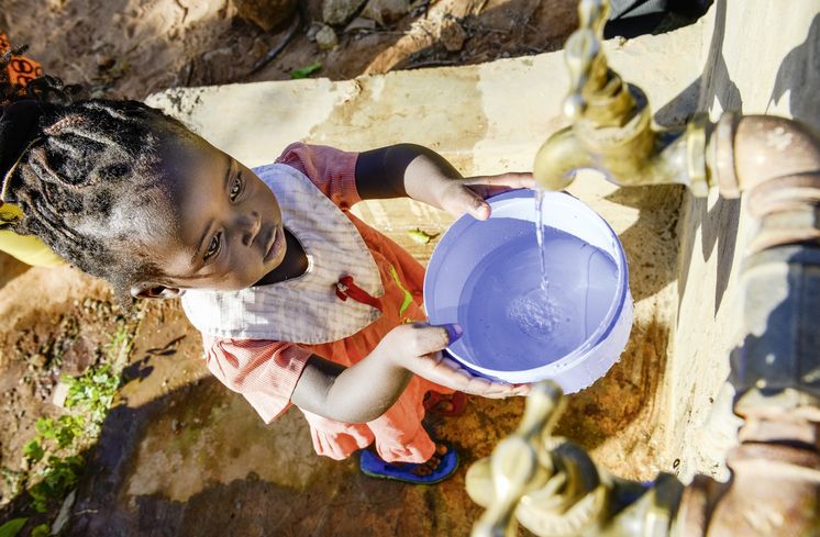 KENIA, ADS Anglican Development Services of Mount Kenya East, Stadt Embu, Dorf Gichunguri, Projekt Regenwasserauffang an einem Felsen und Speicherung in Tanks zur Nutzung in Duerreperioden, Agnes Irima, 44 Jahre, und Enkelin an Wasserstelle