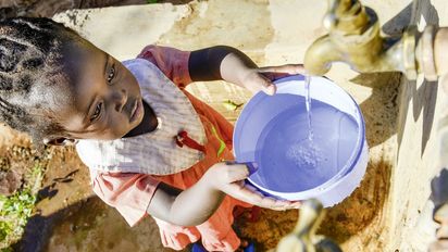 KENIA, ADS Anglican Development Services of Mount Kenya East, Stadt Embu, Dorf Gichunguri, Projekt Regenwasserauffang an einem Felsen und Speicherung in Tanks zur Nutzung in Duerreperioden, Agnes Irima, 44 Jahre, und Enkelin an Wasserstelle