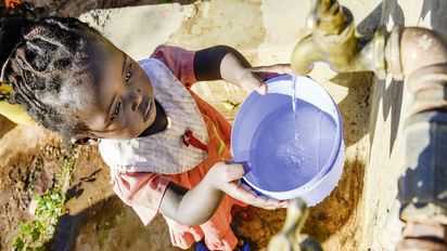 KENIA, ADS Anglican Development Services of Mount Kenya East, Stadt Embu, Dorf Gichunguri, Projekt Regenwasserauffang an einem Felsen und Speicherung in Tanks zur Nutzung in Duerreperioden, Agnes Irima, 44 Jahre, und Enkelin an Wasserstelle