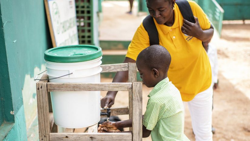 Ein Junge wäscht sich die Hände an einem Wasserspender.
