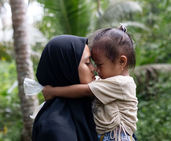 Die 24-jährige Samrotul Puadah mit ihrer zweijährigen Tochter Noora in ihrem Zuhause in Bojung, Pandangerang, West-Java. Samrotul, auch bekannt als Aii, war eine der zwölf Gewinner*innen des Wettbewerbs für junge Landwirt*innen. Sie beschloss, mit der Landwirtschaft zu beginnen, um sich zu beschäftigen, während ihr Mann als Maler unterwegs war. Partnerorganisation: JAMTANI