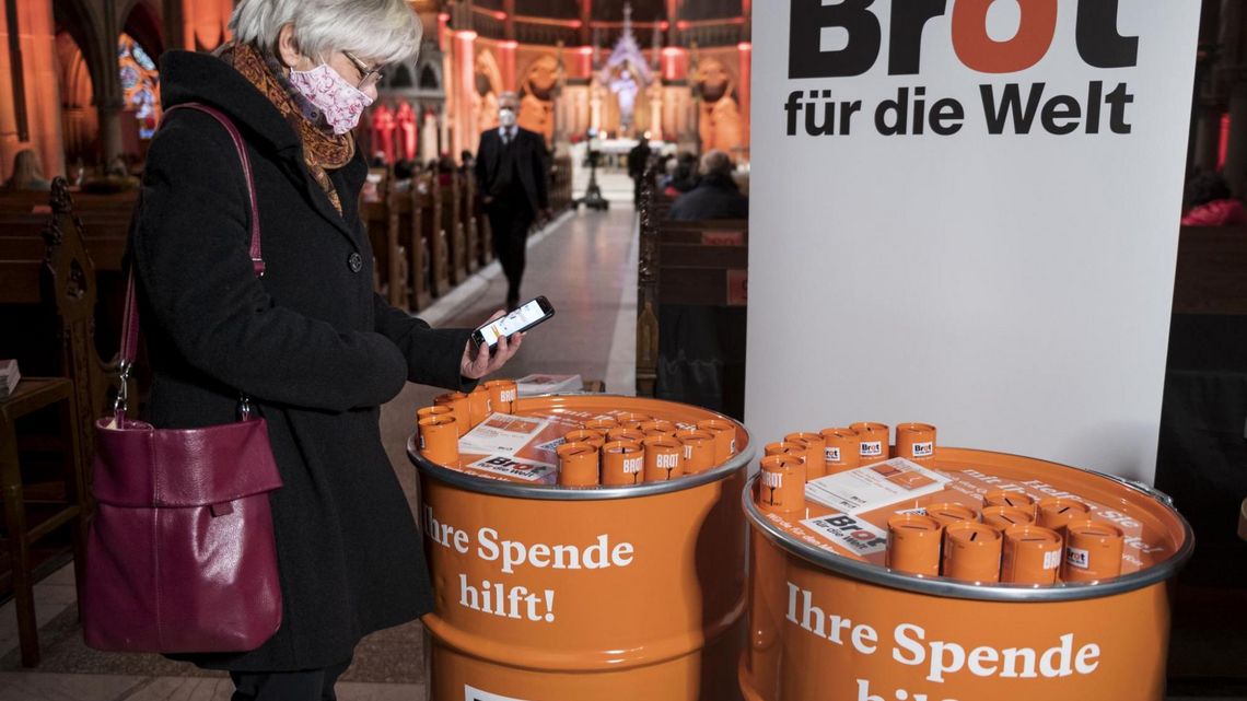 Eine Frau informiert sich über Kollekten und Spendenmöglichkeiten. 