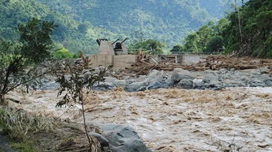 Fluss reisst Häuser weg