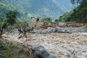 Fluss reisst Häuser weg