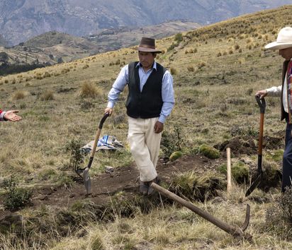 Arariwa in Cusco kümmert sich um die Entwicklung von nachhaltiger Familienlandwirtschaft in der Region.Gemeinsame Anlage von Sickergräben.Der Arariwa Mitarbeiter Renan Mamani Suca (oranges T-Shirt) erklärt die Anlage von Sickergräben am Berghang, damit das Regenwasser besser in das Erdreich eindringen kann.Projektpartner: ARARIWA - Asociacion Arariwa