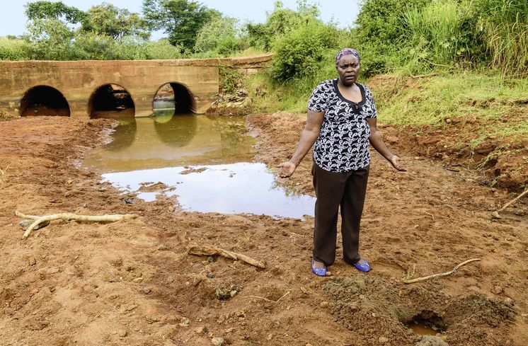 KENIA, ADS Anglican Development Services of Mount Kenya East, Stadt Embu, Weg nach Dorf Gichunguri, Dorfbewohner muessen Wasser ueber weite Entfernungen transportieren, verschmutzte Wasserstelle in einem trockenen Flussbett, ADS Mitarbeiterin Mary Gichobi
