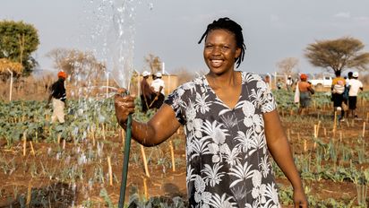 Beauty Nyathi (45) waessert ihr Feld im Community-Garten