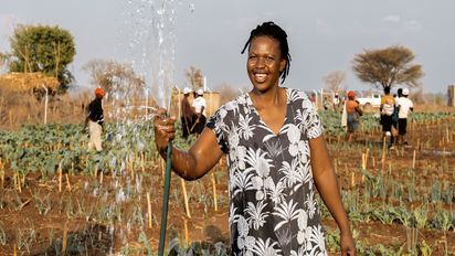 Beauty Nyathi (45) waessert ihr Feld im Community-Garten