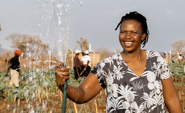 Beauty Nyathi (45) waessert ihr Feld im Community-Garten