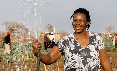 Beauty Nyathi (45) waessert ihr Feld im Community-Garten