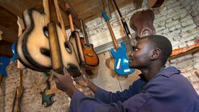 Ehemaliger Kindersoldat in der Demokratischen Republik Kongo in seinem Beruf als Gitarrenbauer