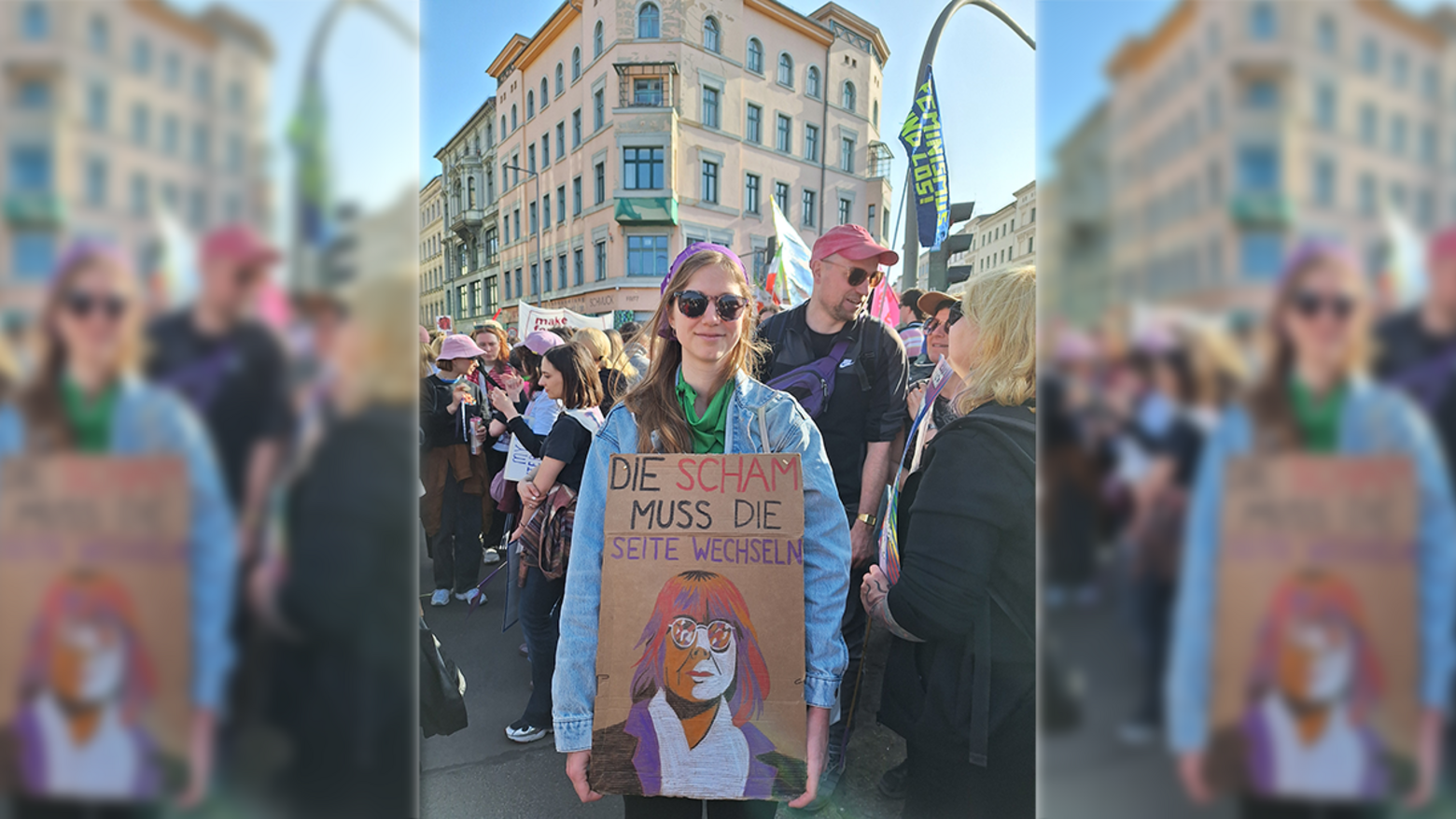 Demo-Teilnehmerin mit Plakat mit Konterfei von Gisele Pelicot und der Aufschrift "Die Scham muss die Seiten wechseln!"