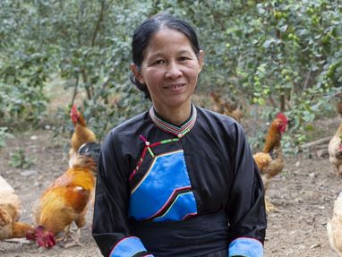 Portrait von Hien Khuong Thi mit ihren Hühnern im Hintergrund