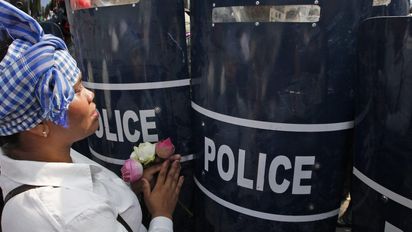 epaselect epa04114847 A Cambodian protester pleads with police officers during a rally in Phnom Penh, Cambodia, 08 March 2014. Local worker unions and Human Rights activists are calling Cambodian authorities to release garment workers who have been arrested during a protest to demand a wage increase on 02 and 03 January 2014. Foto: Mak Remissa/picture alliance/dpa/EPA