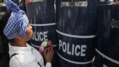 epaselect epa04114847 A Cambodian protester pleads with police officers during a rally in Phnom Penh, Cambodia, 08 March 2014. Local worker unions and Human Rights activists are calling Cambodian authorities to release garment workers who have been arrested during a protest to demand a wage increase on 02 and 03 January 2014. Foto: Mak Remissa/picture alliance/dpa/EPA