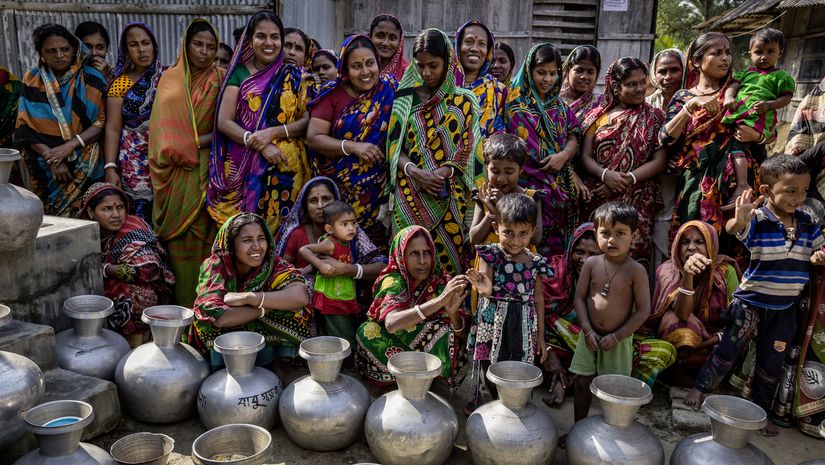 Frauen aus der Umgebung warten vor der Wasserstelle um die Wasserkrüge zu füllen