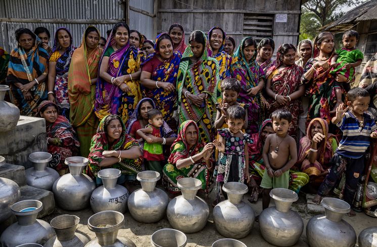 Frauen aus der Umgebung von der Wasserstelle Vamia warten darauf ihre Wasserkruege mit dem von CCDB im Solarbetrieb aufbereiteten Wasser zu fuellen. Die Menschen in den kleinen Siedlungen an den Fluessen in der Naehe von Shyamnagar in Sued Bangladesch, spuehren deutlich den Klimawandel. Der Meeresspiegel steigt und Daemme werden zerstört. Da durch werden Felder und die wichtigen Suesswasserteiche ueberflutet und versalzen. CCDB Bangladesch arbeitet an Suesswassergewinnungs-Projekten und sorgt dafuer, dass die Menschen nach und nach sauberes Trinkwasser erhalten.
