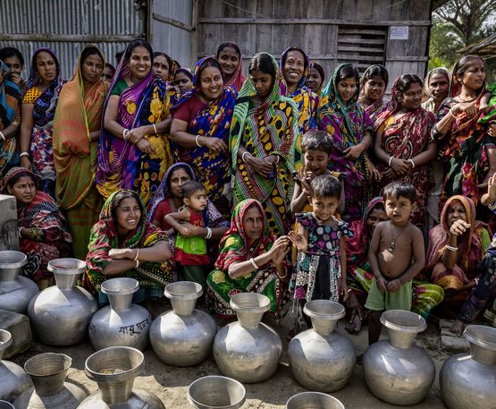Frauen aus der Umgebung warten vor der Wasserstelle um die Wasserkrüge zu füllen