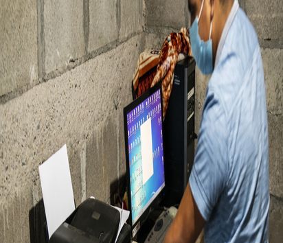 Buchhalter des Stromkollektivs AMALUNA am Arbeitsplatz mit eionem Computer und Drucker