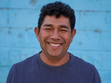 Portrait von William Patricio Chunga Rojos vor einer blauen Steinwand