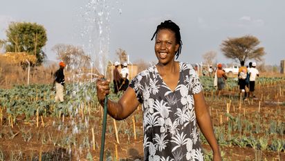 Beauty Nyathi (45) wässert ihr Feld im Community-Garten.Partnerorganisation: Consorcio