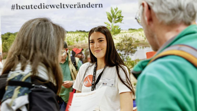 Mitarbeitende im Gespräch mit zwei Messebesucher*innen