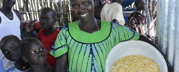 AETHIOPIEN, Gambela, Projekte EECMY-DASSC, Region Itang, Dorf Pilual der Ethnie NUER,Herr Mun Kunen und Frau Neelam , sie sind vor dem Buergerkrieg aus dem Suedsudan gefluechtet, seine Frau Neelam, gruenes Kleid, in der Getreidemuehle des Projektes - Projektpartner Ethiopian Evangelical Church Mekane Yesus/Development and Social Service Commission (EECMY-DASSC)