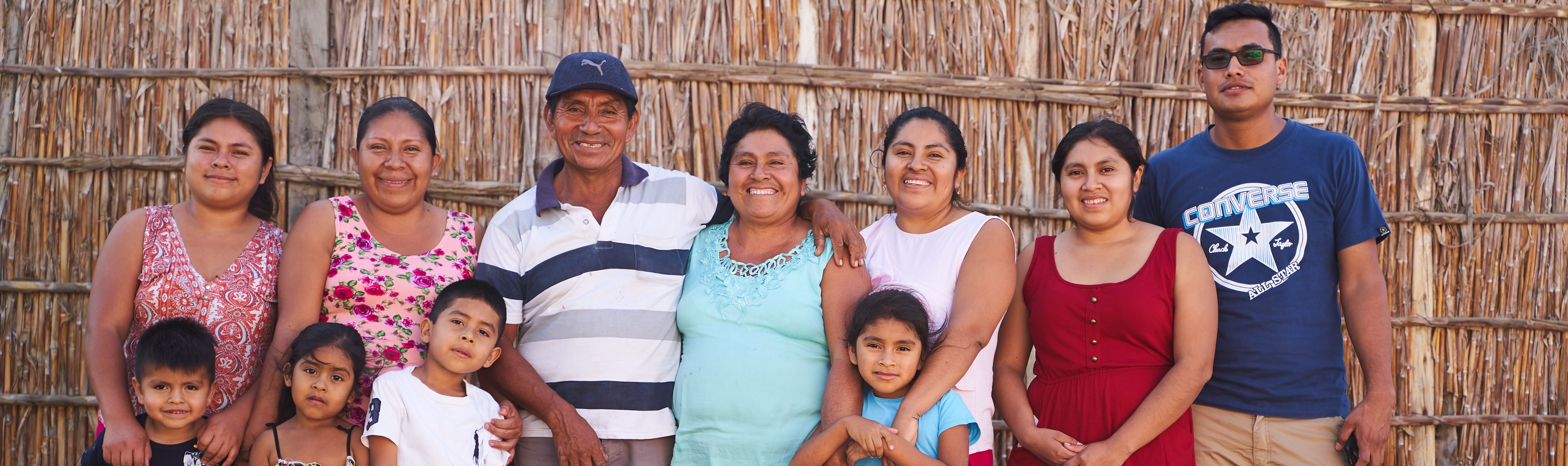 Peru, CEDEPAS NORTE, Region Piura, La Huaca. Familienportrait. Von Links nach Rechts (Oben): Schwägerin Pamela, die älteste Tochter Danitza, Vater Francisco Imán Vílchez (Asociación Valle del Chira), Mutter Elizabeth Mendoza Fernández, die mittlere Tochter Judit, die jüngste Tochter Maria Lorena und ihr Freund Misael. Unten: Enkelkinder Yair, Bianca, Diego und Lucero.Vor 5 Jahren war die Familie fast mittelos, heute haben sie ein gutes Einkommen durch Fair Trade Bananen.