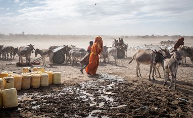 Projektpartner: RACIDAFrauen, Männer und Kinder nähern sich einer Wasserstelle, um ihre leeren Kanister in den trockenen, windgepeitschten Ebenen in der Nähe von Lanqoot, im Bezirk Wajir im Nordosten Kenias, aufzufüllen. Der Nordosten Kenias liegt in einer Region Ostafrikas mit trockenem Klima und einem chronischen Mangel an natürlichen Ressourcen. Die Haupteinnahmequelle der Menschen hier ist die nomadische Tierhaltung. Doch der Klimawandel führt zu immer häufigeren Dürren und unvorhersehbaren Niederschlagsmustern - und damit zu einer zunehmenden Verknappung von Weideland und Wasserquellen für die Tiere, auf die so viele hier angewiesen sind. Infolgedessen müssen die Menschen in diesen Regionen täglich darum kämpfen, über die Runden zu kommen. Fehlender Regen kann den Unterschied zwischen Leben und Tod ausmachen.
