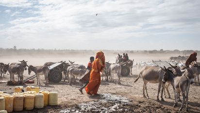 In der Nähe von Lanqoot im Nordosten Kenias füllen Frauen und Kinder ihre Wasserkanister an einer Wasserstelle auf. Die Region hat ein trockenes Klima und einen chronischen Mangel an natürlichen Ressourcen. Der Klimawandel führt zu immer häufigeren Dürren und unvorhersehbaren Niederschlägen.