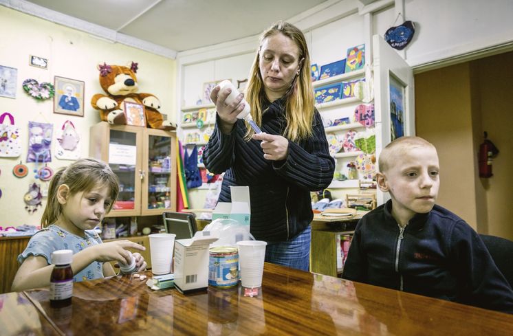 Novoye Vremya, AIDS, HIV, Jekaterinburg, Russland,Abendliche Medikamenteneinnahme bei Swetlana Worobjova und ihren ebenfalls HIV infizierten Kinder Kristina Worobjova und Kolja Worobjova im Zentrum der Hilfsorganisation Novoye Vremya in Jekaterinburg, wo die Familie viele Hilfestellungen bei der Bewaeltigung ihres Lebens mit dem Virus und ihrer sozialen Situation bekommt.