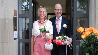 Frisch verheiratetes Ehepaar am Eingang des Standesamtes