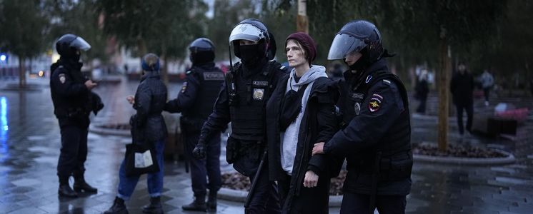 Polizisten führen einen Demonstranten in Moskau ab